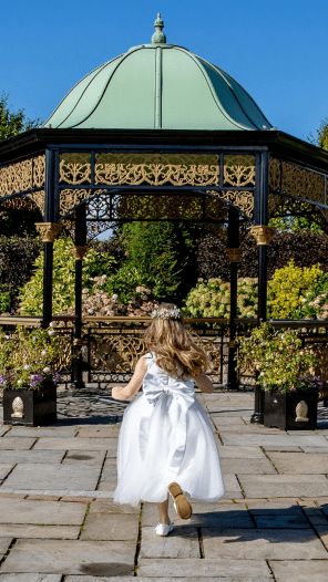 Flower girl running towards gazebo