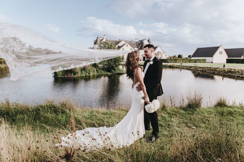 Bride and groom next to lake