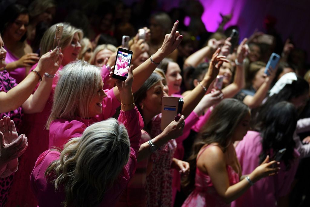 Adoring crowd watching with phones aloft