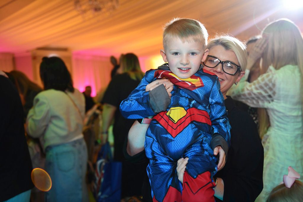 Superman wee boy held by mother
