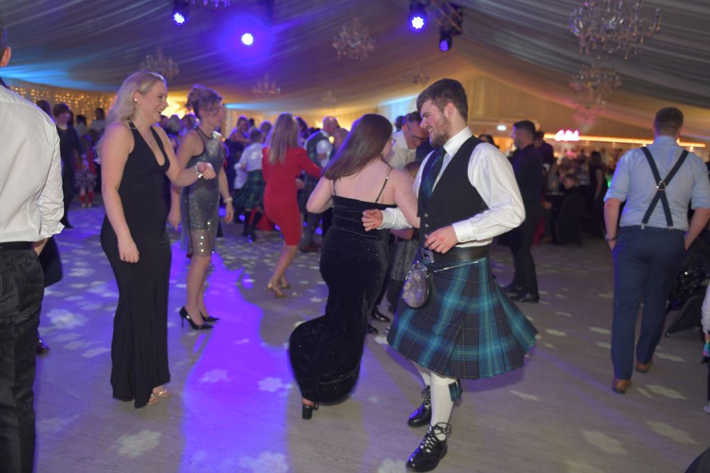 Man in kilt ceilidh dancing with lady